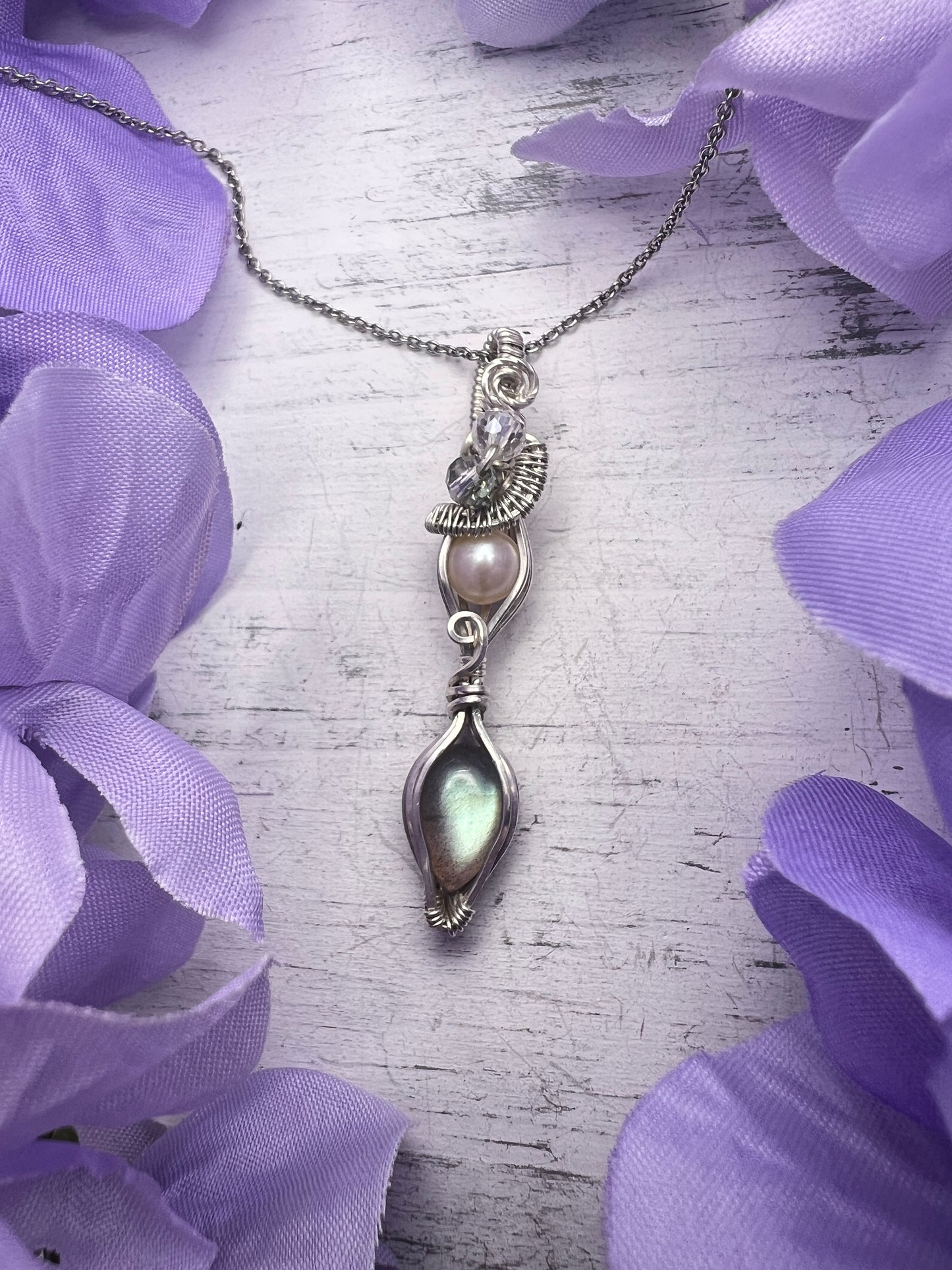 Handmade silver pendant with white pearl and flashy labradorite on lavender floral background